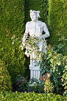 The Satyr. C18th French statue. Hedge of Thuja occidentalis Smaragd behind. Orekhovno garden, Orekhovno, Pskov Oblast region, Western Russia.