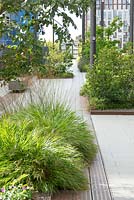 Raised beds along bridge between city buildings. 