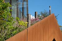 Modern lights on corten steel bridge planted with Anemone, Asters, Persicarias and trees.