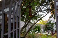 Trellis frame around garden mirror used at boundary to create more space showing reflection of garden