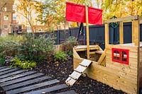 Play area with pirate ship playhouse in the back garden.
