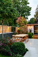 Contemporary garden in Wandsworth showing garden lighting. With stone patio, seating, tables and garden room 