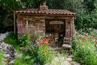 Wildflowers: poppies, foxgloves, buttercups, cow parsley and ragged robin in The Old Forge for Motor Neurone Disease Association Garden - RHS Chelsea Flower Show 2015.