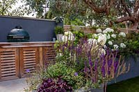 London contemporary garden - bespoke barbecue on patio with grey raised border. Planting includes Heuchera berry smoothie, Salvia caradonna, Hydrangea anabelle, Geranium johnsons blue.