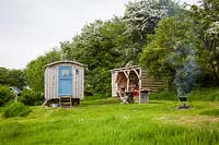 View to rustic kitchen hut and shepherds hut at wild Meadows 