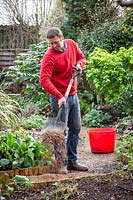 Resurfacing a path by spreading gravel, raking it even and tamping it down