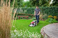 Mowing a lawn with a petrol lawnmower