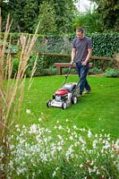 Mowing a lawn with a petrol lawnmower