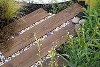 'Find Yourself Lost in the Moment' garden - RHS Chatsworth Flower Show 2019 - view of path showing mixed materials.