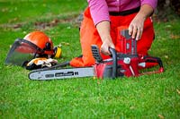 Rechargeable battery-powered cordless chainsaw and safety helmet