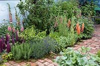 Perennials line an old brick path in 'An Imagined Miner's Garden', designed by Colin and Mary Bielby at RHS Chatsworth Flower Show, 2019.
