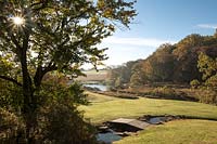 Distant view across landscape with meandering river and wooden bridge