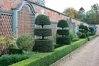 Italianate garden, view along wall with painted trellis and line of tightly clipped Taxus - Yew - and Buxus - Box - edging 