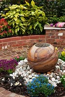 Circular paved area with central water feature and seating - 'At the End of the Day' Show Garden, Silver Gilt Award, Harrogate Spring Flower Show 2013