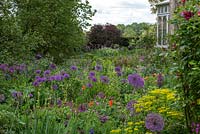 Open vistas and overflowing beds of alliums and herbaceous perennials make for a relaxed natural feel, whilst trees, box hedges and clipped balls give structure.
