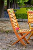 Wooden garden furniture painted in bright colours of pink, green and orange.