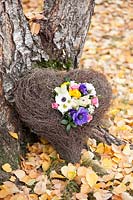 Heart shaped display of camomile, roses, ranunculus, anemone