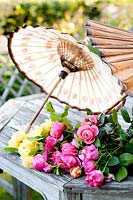 Freshly cut flowers from the garden displayed on the garden table with a parasol