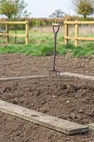 Garden fork and boards for ground preparation in new kitchen garden 
