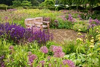 Wooden seats in The Perennial Meadow, at Scampston Hall Walled Garden, North Yorkshire, UK. 