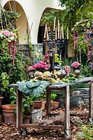 Autumn table decorated with hydrangeas, carnations, amaranth, pumpkins, grapes, savoy cabbage and mushrooms and candlesticks