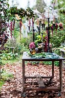 Autumn table decorated with hydrangeas, carnations, amaranth, pumpkins, grapes, savoy cabbage and mushrooms and candlesticks