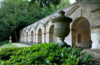 Classical urn, behind a view along The Praeneste Terrace with its series of seven stone arches