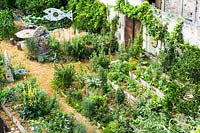 Overview of vegetable garden with sculptures.
