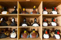 Display of pairs of wooden duck ornaments painted and finished on shelf