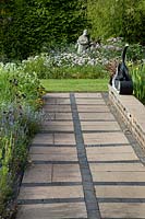 Geometric paving leading to the wildflower bed with sculpture 