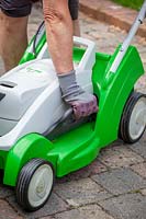 Raising the height of lawnmower blades before cutting a lawn during a dry spell