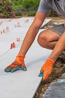 Man adjusting a freshly laid context Porcelain slab