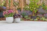 Pots of colourful plants sat upon context porcelain patio