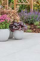 Pots of colourful plants sat upon context porcelain patio