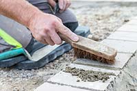 Man using small brush to remove excess grout