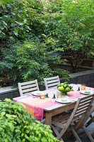 View over dining area, screened by shrubs such as Indigofera