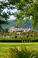 View over lawn to geometric garden with Spello in the background