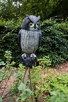 Owl sculpture in garden. 