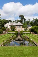 View of the Tranquility Pond and Thunder House, with steps leading up to the main lawn and house on the left and to the tennis court on the right. Metal sculpture by Fire and Iron.