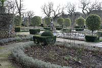Parterre, view over bed with metal plants supports to lollipop topiary