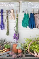 Rustic boards with wooden pegs attached for storing string and gloves. 