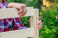 Close up detail of inserting wooden side panels into a pre-cut grove