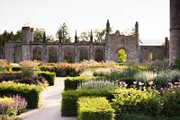 Parterre with low blocks of Taxus - Yew - framing herbaceous perennials including Filipendula venusta 'Rubra' and Veronicastrum virginicum 'Spring Dew', castle behind