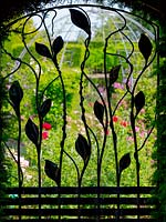 Decorative wrought iron gate leading to rose garden 