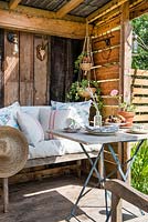 Rustic furniture on verandah including cushions