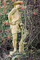 Statue of a gardener resting on his spade at the Old Rectory, Netherbury, UK. 