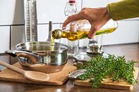 Pouring olive oil in saucepan