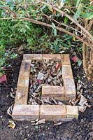 Hedgehog house with fallen leaf bedding ready for adding the roof