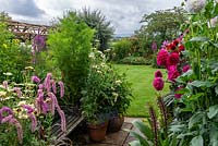Looking out from a half-acre country garden over dahlias, a rustic pergola, lawns and borders of summer perennials, to a rural vista of Blackmore Vale.