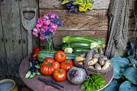 Summer vegetables in a rustic setting. Courgettes, Beefsteak Tomatoes, Mint, climbing French Beans, Inca Gold Potatoes, Statice, Sweet Peas, Boltardy Beet.
